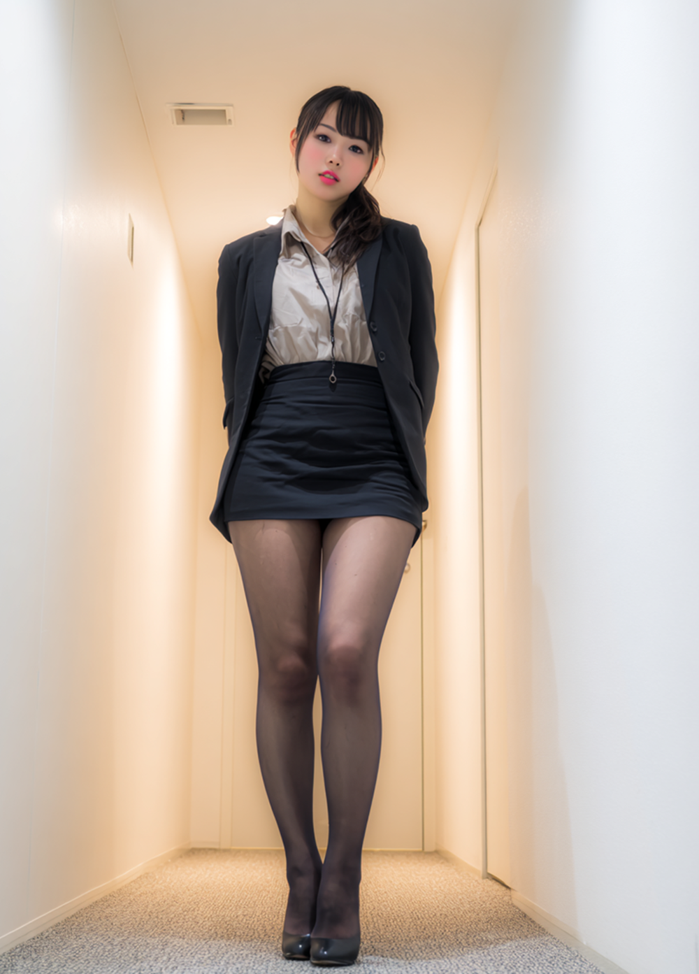 Low angle view of a secretary in office attire, black skirt and tights, commanding presence.