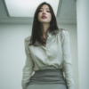 Realistic Japanese office lady wearing white silk blouse and grey tight pencil skirt, cinematic office lighting, professional aesthetic, detailed skin texture, high resolution AI photography.