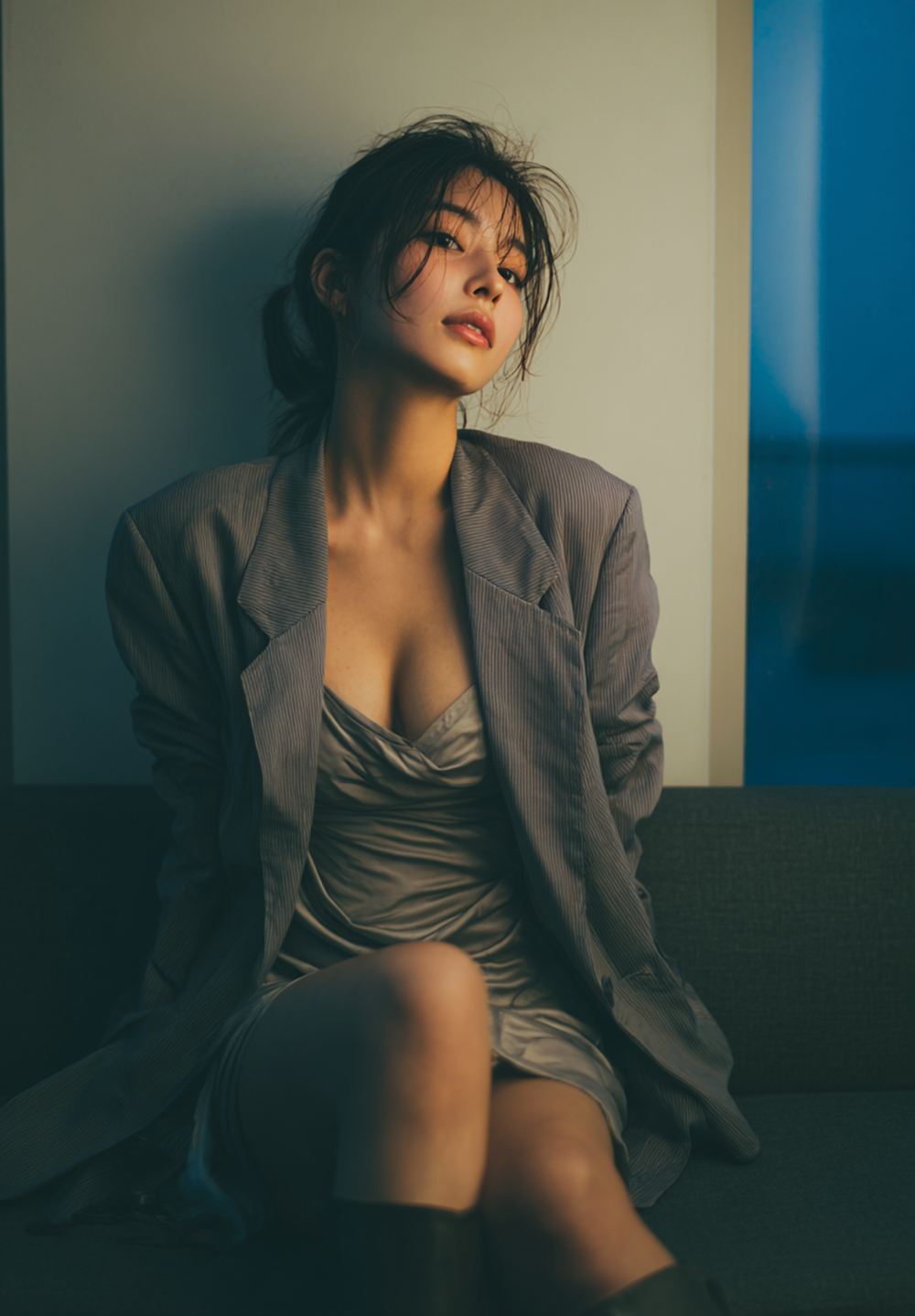 Beautiful Japanese woman with wet hair wearing a navy blazer and satin slip dress in a luxury hotel suite, cinematic lighting, realistic skin texture, moody atmosphere, office lady after work.