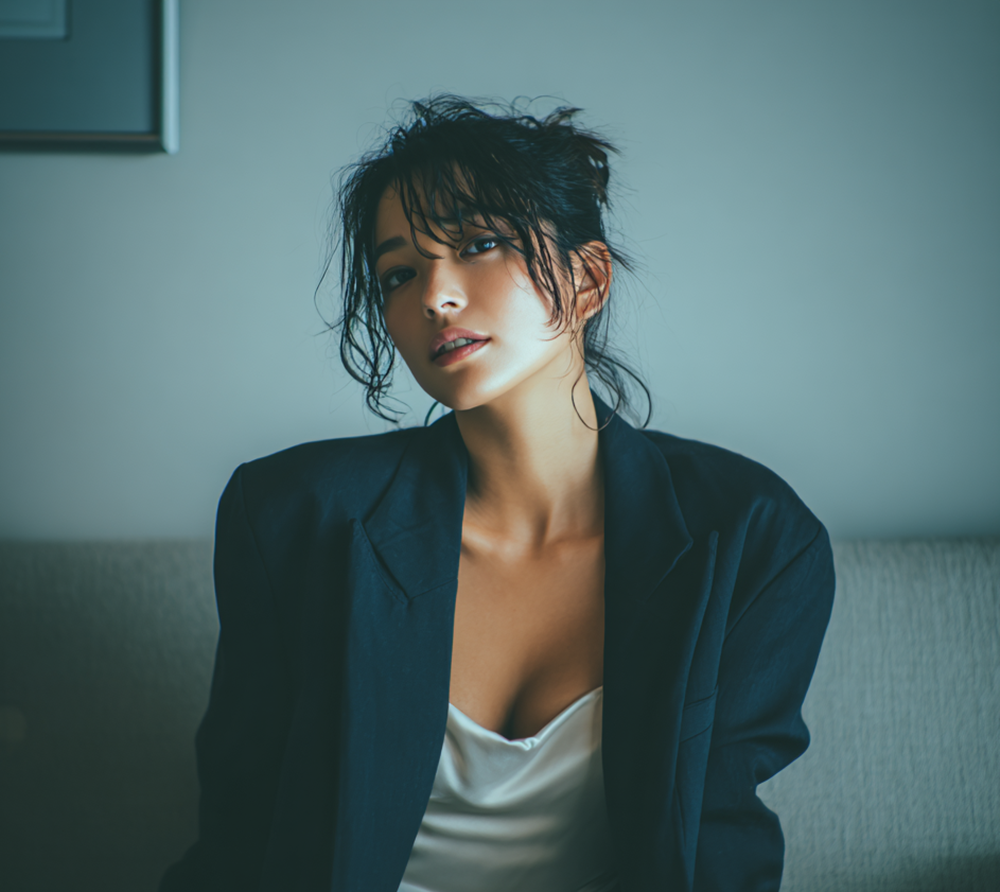 Beautiful Japanese woman with wet hair wearing a navy blazer and satin slip dress in a luxury hotel suite, cinematic lighting, realistic skin texture, moody atmosphere, office lady after work.