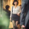 夕方のオフィスビルから出てくる白ブラウスと黒ストッキング姿のOL